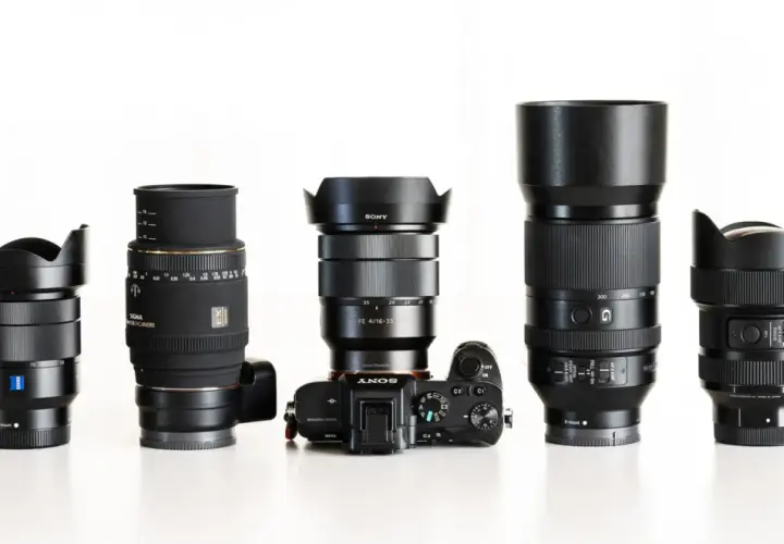 Pięć obiektywów fotograficznych i aparat Sony Alpha ustawione w rzędzie na białym tle.